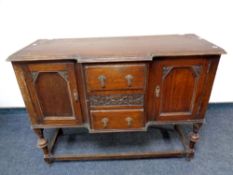 An early twentieth century oak shaped fronted sideboard