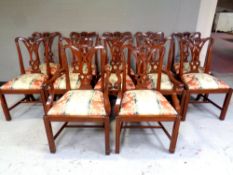 A set of 12 reproduction mahogany dining chairs comprising of two carvers and ten singles