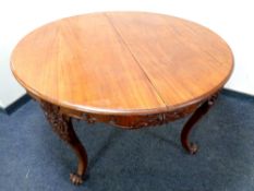 A circular continental mahogany table on cabriole legs