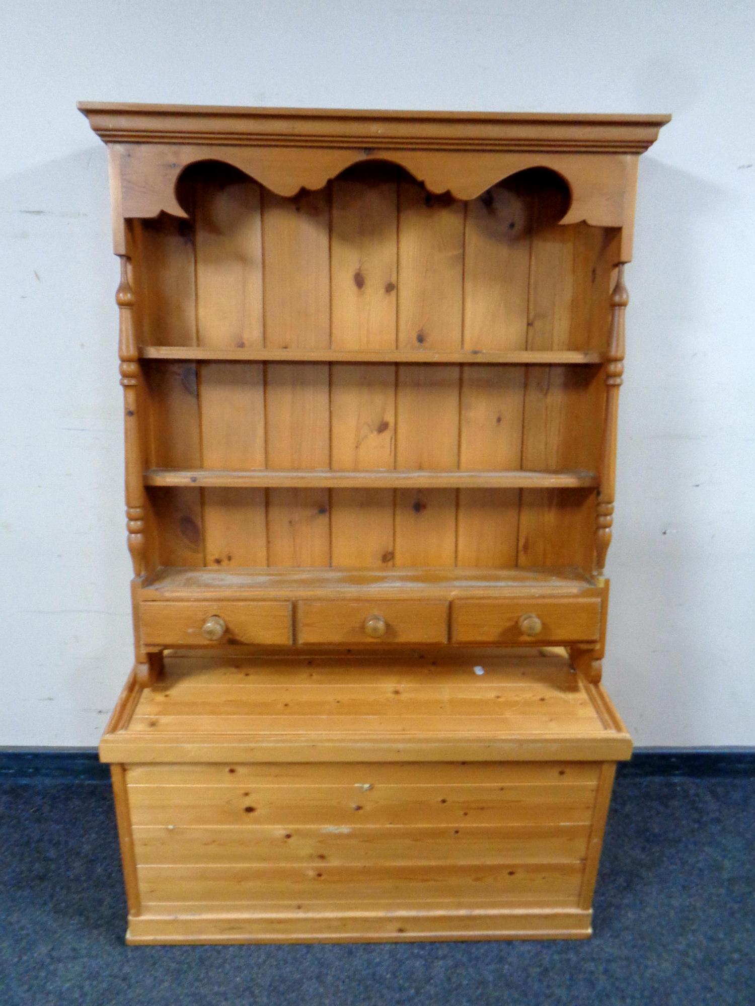 A pine Delft rack fitted with three drawers together with a pine blanket box