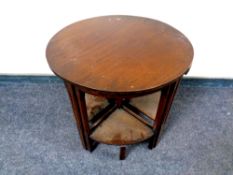 A 20th century circular occasional table fitted four tables beneath