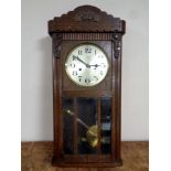 A twentieth century oak cased wall clock with silvered dial