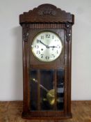 A twentieth century oak cased wall clock with silvered dial