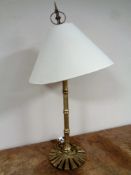 A brass table lamp with shade, height 76 cm.