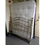A contemporary 4'6 chrome metal bed frame with mattress