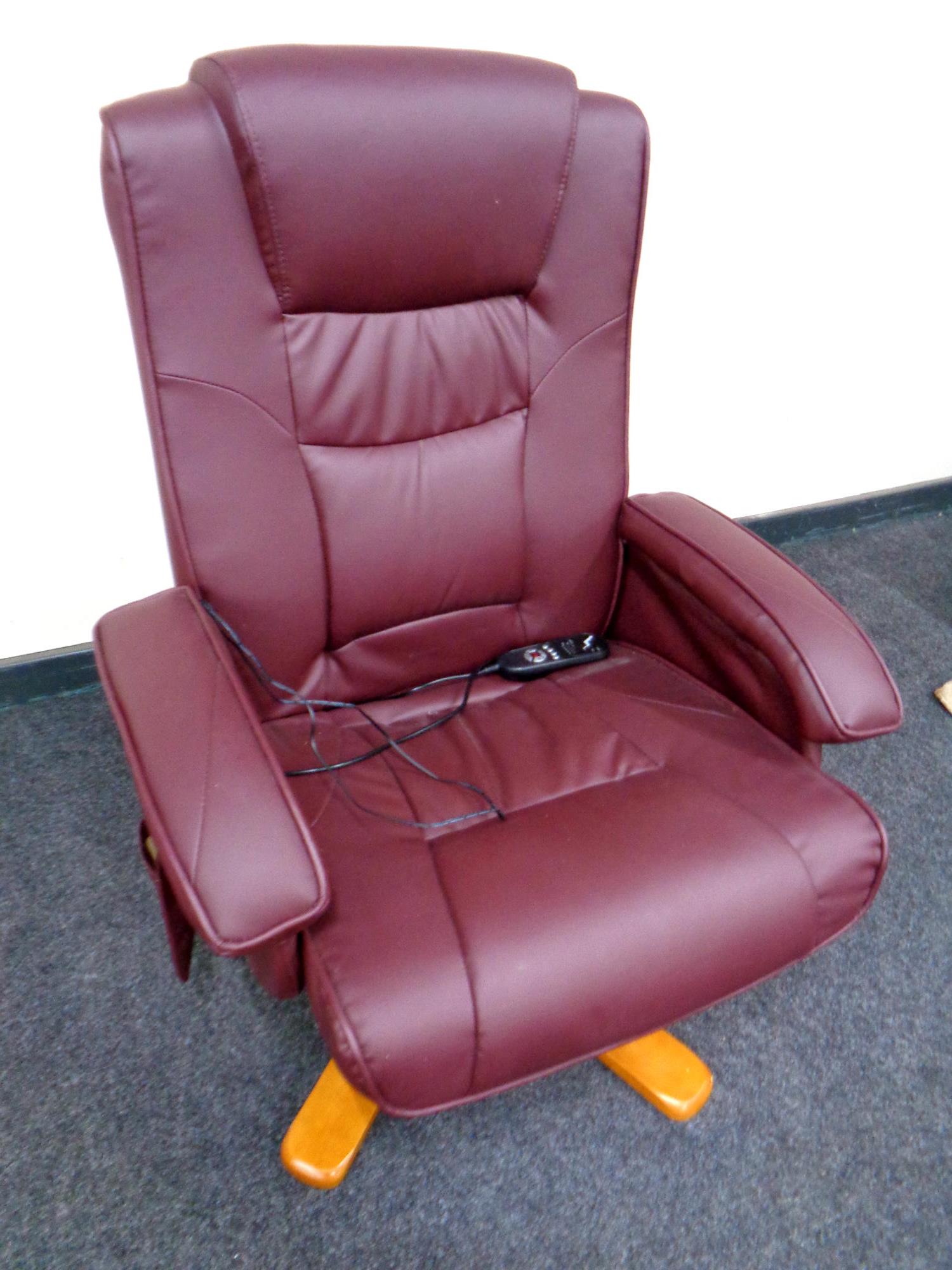 A Burgundy leather swivel electric reclining armchair