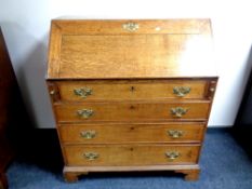 A George III oak fall front writing bureau fitted four drawers beneath on bracket feet,