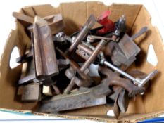 A box containing vintage woodworking tools to include hand planes, saws,