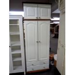 A painted pine double door nursery wardrobe, fitted two drawers beneath,