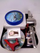 A tray containing aviation themed wall clock, metal desk clock, coins, watch,
