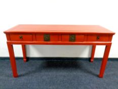 A Chinese red lacquered side table fitted four drawers on raised legs,