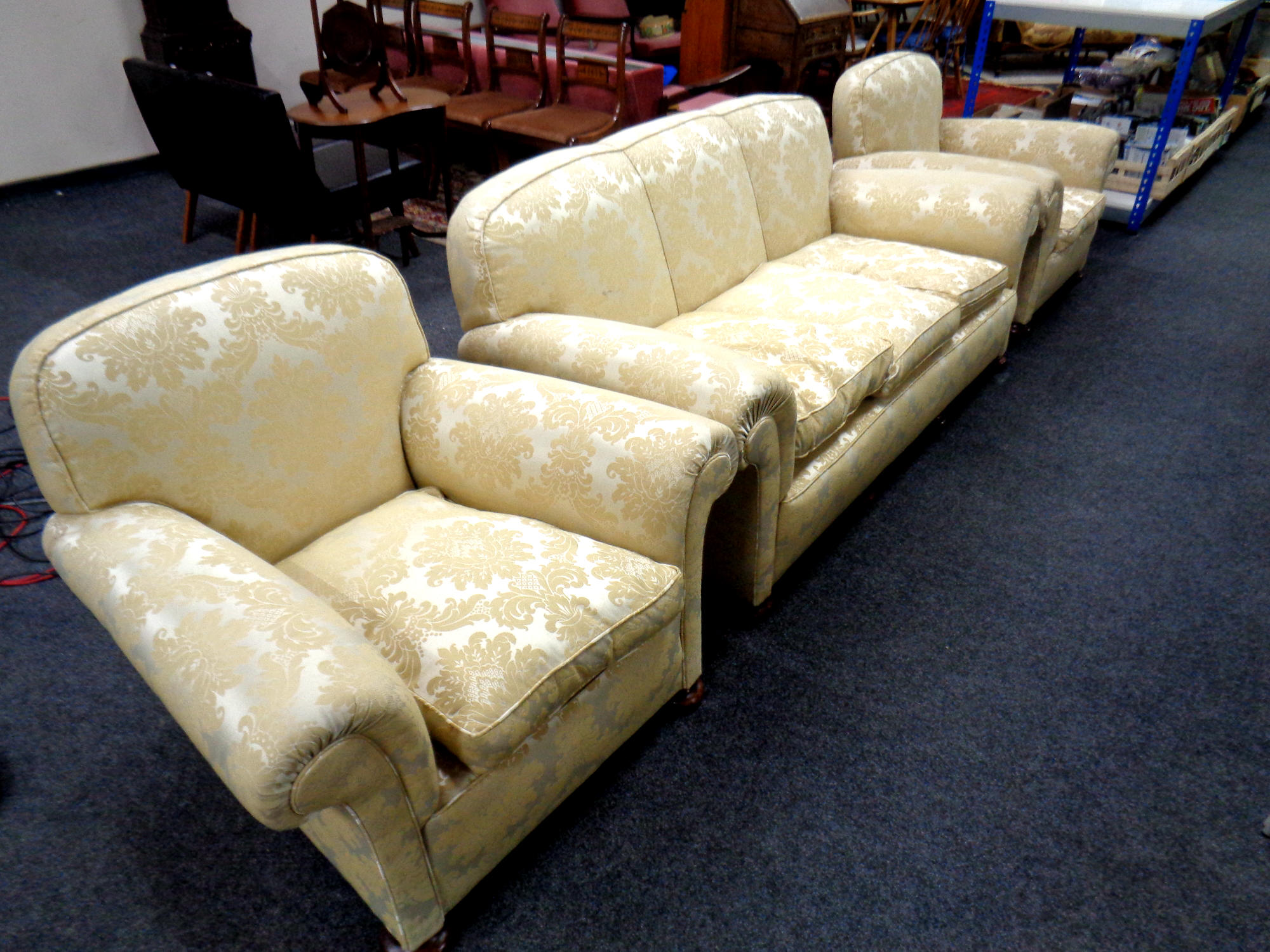 An Edwardian three piece lounge suite upholstered in a gold classical print