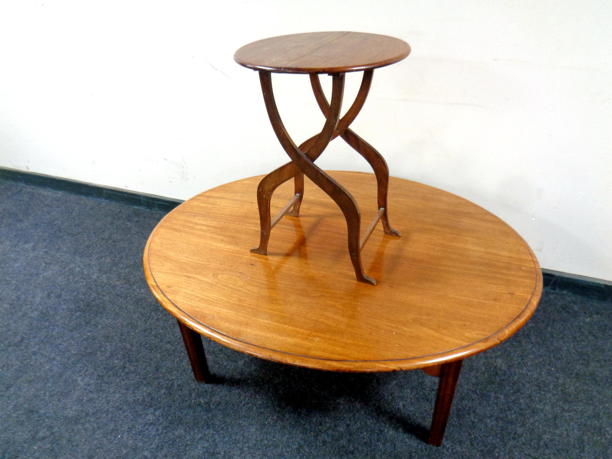 An oval mahogany table with cut down legs together with a further folding occasional table