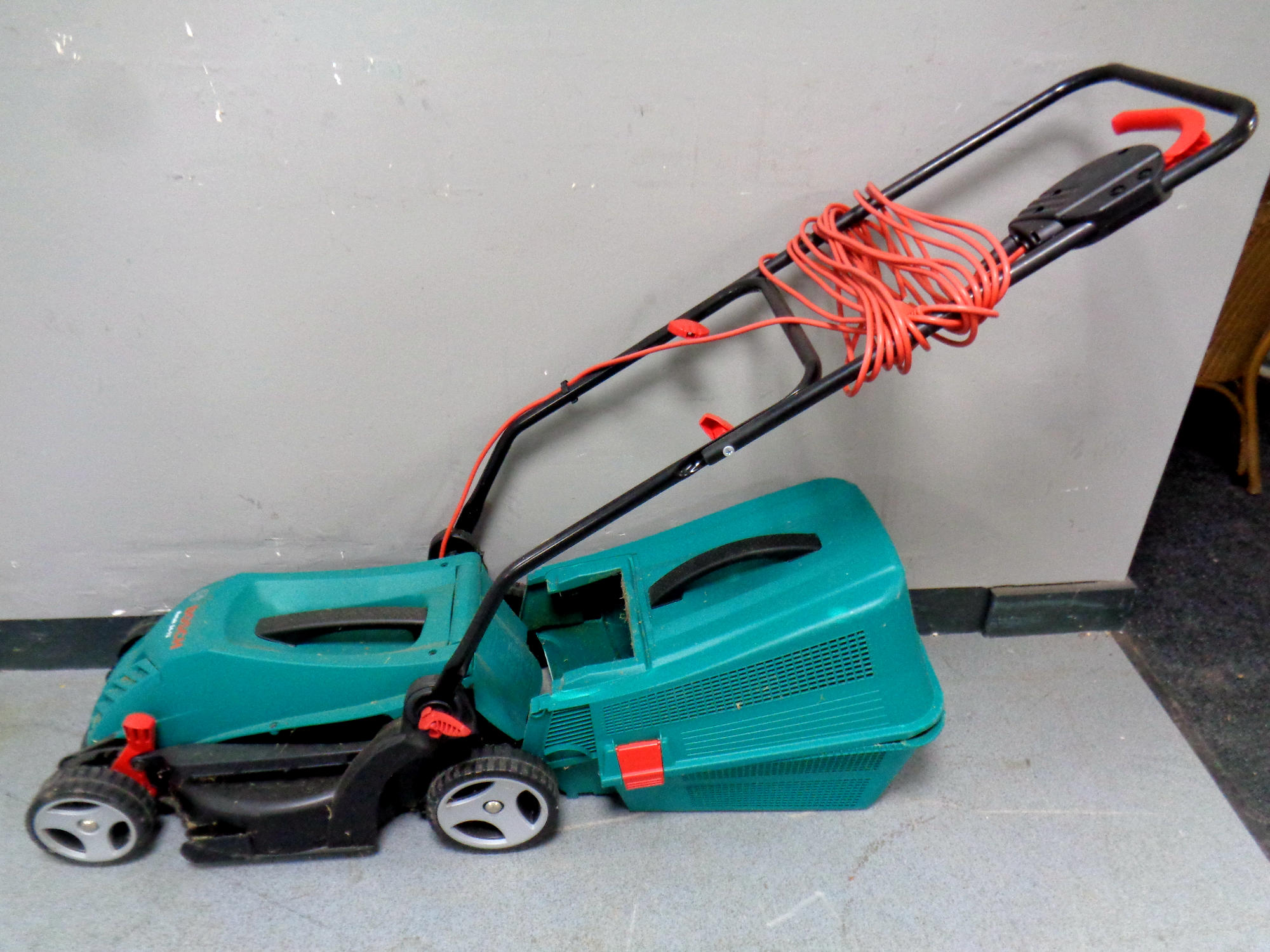 A Bosch Rotak 34-13 electric lawn mower with grass box and lead