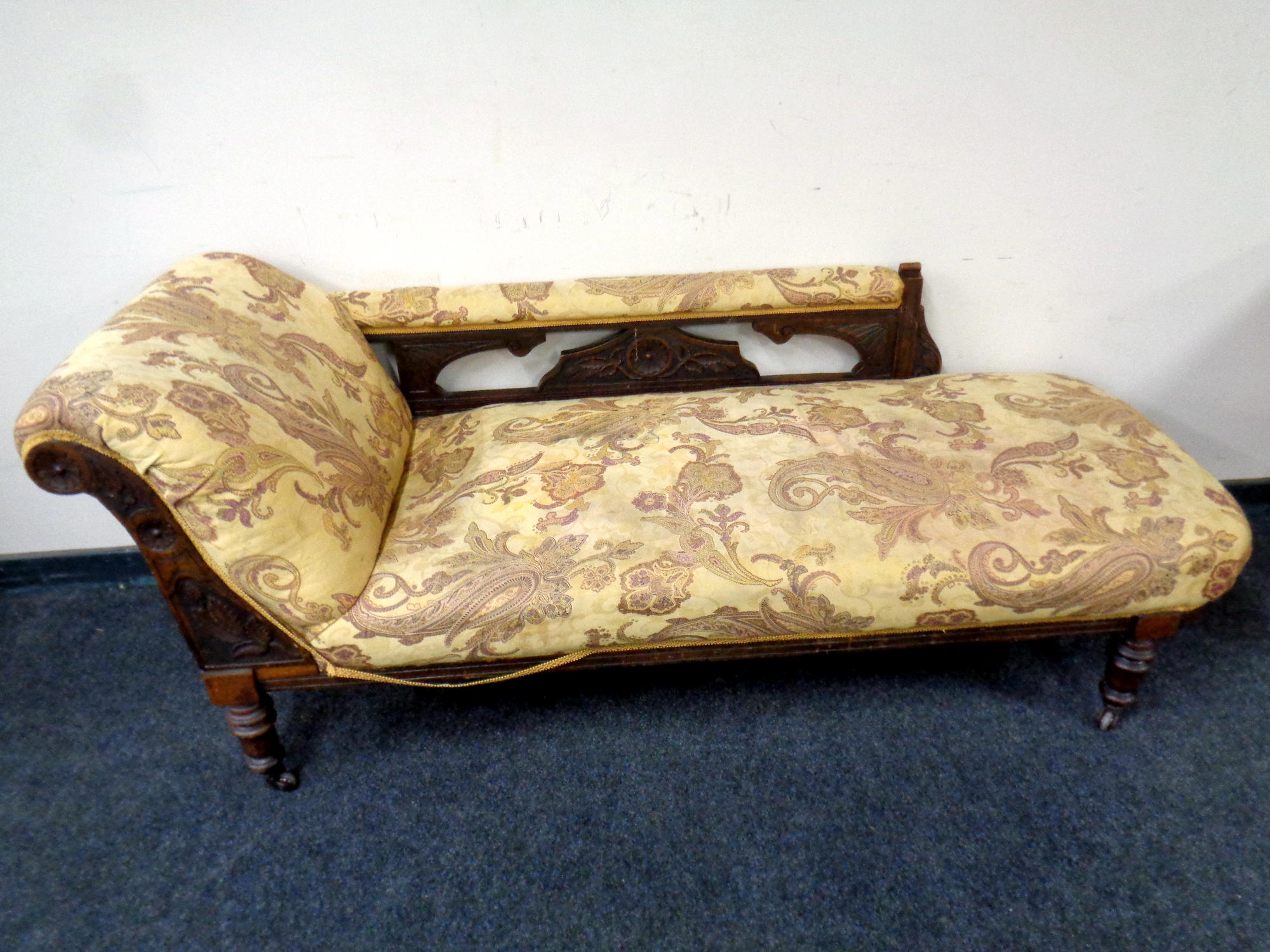 A 19th century carved mahogany chaise longue upholstered in a paisley patterned print