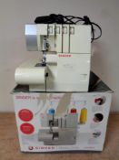 A Singer heavy duty 14HD854 over locking sewing machine with foot pedal in box