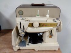 A 20th century Singer electric sewing machine with foot pedal in case