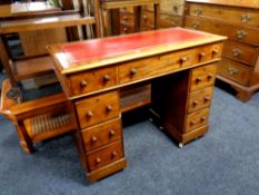 A Victorian mahogany child's desk fitted nine drawers with a red leather inset panel,