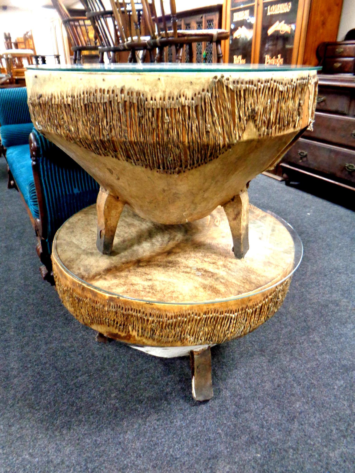 Two circular animal hide drum tables with glass tops