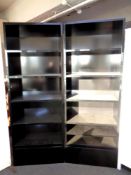A pair of black high gloss open bookshelves fitted with a drawer beneath