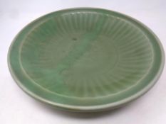 A Chinese celadon stoneware dish with ribbed decoration,