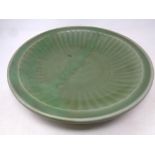 A Chinese celadon stoneware dish with ribbed decoration,