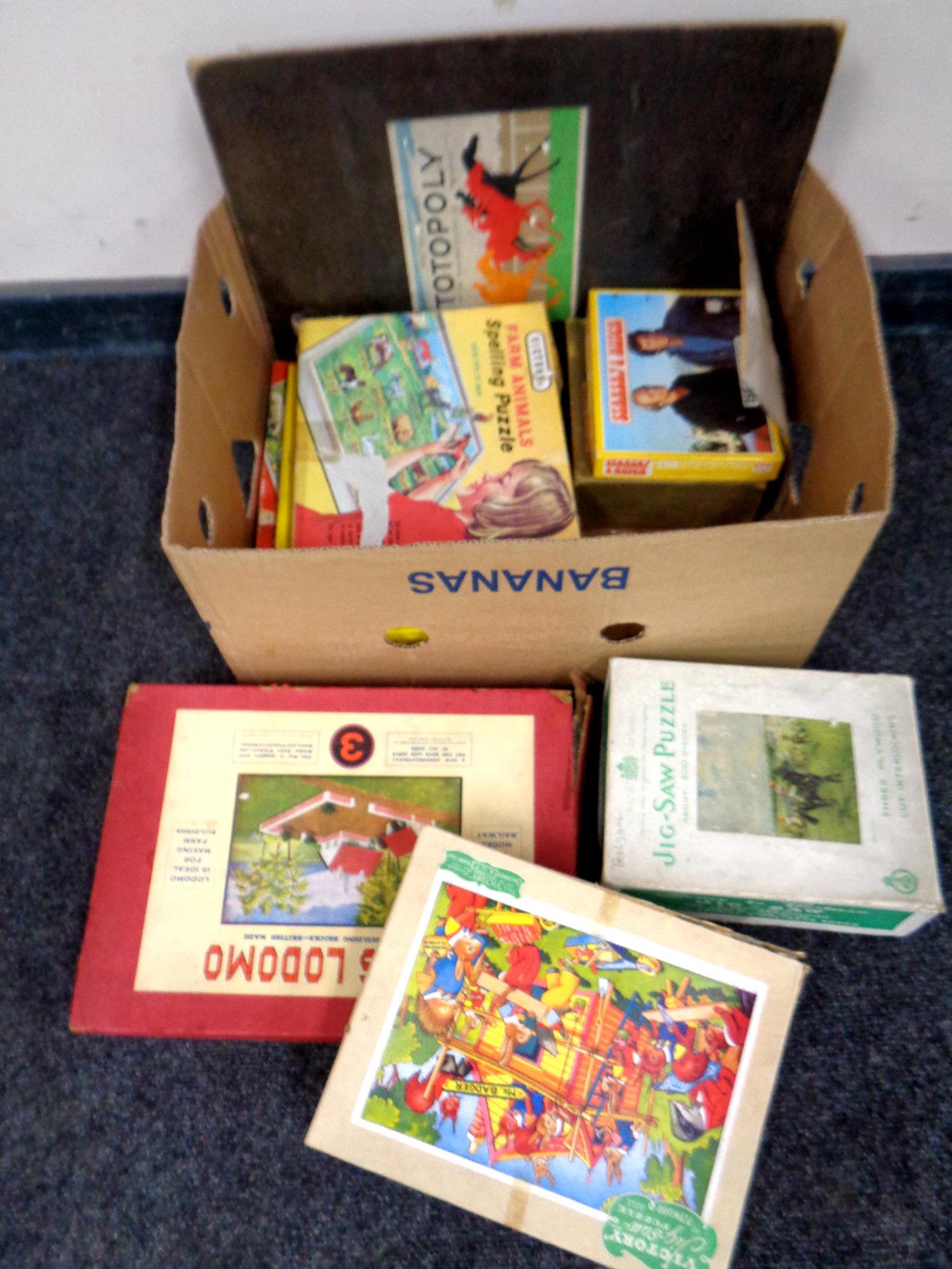 A box containing vintage jigsaws and games together with a Lotts Lodomo construction set