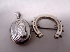 A silver horse locket and horseshoe brooch