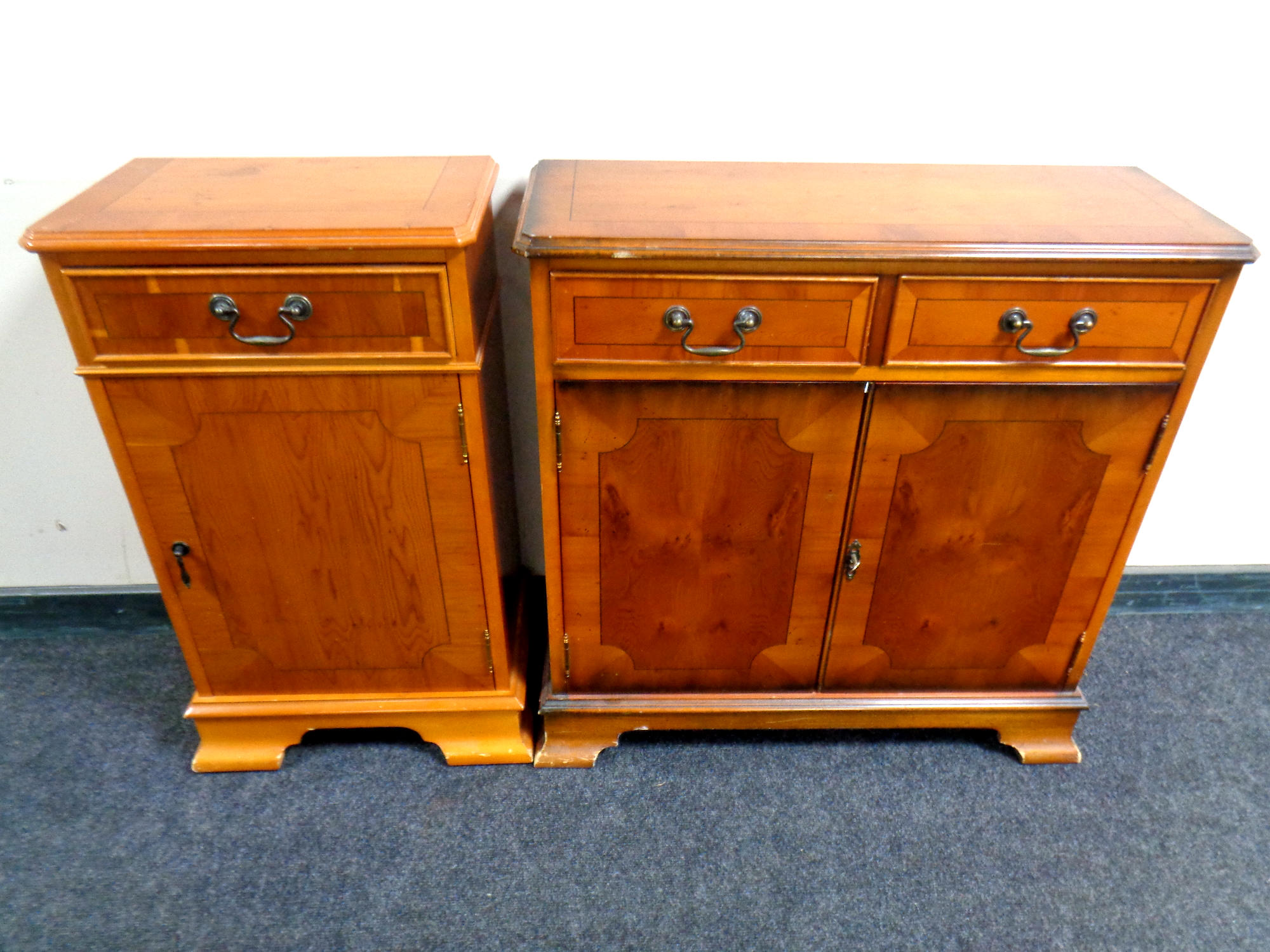 An inlaid yew wood double door cupboard fitted two drawers above together with similar one drawer