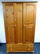 A pine double door wardrobe fitted two drawers beneath,