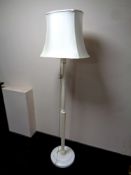 A painted standard lamp with shade