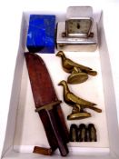 A box containing a vintage hunting knife in leather sheath, a pair of brass ornaments, pigeons,