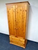 A pine double door wardrobe, fitted two drawers,