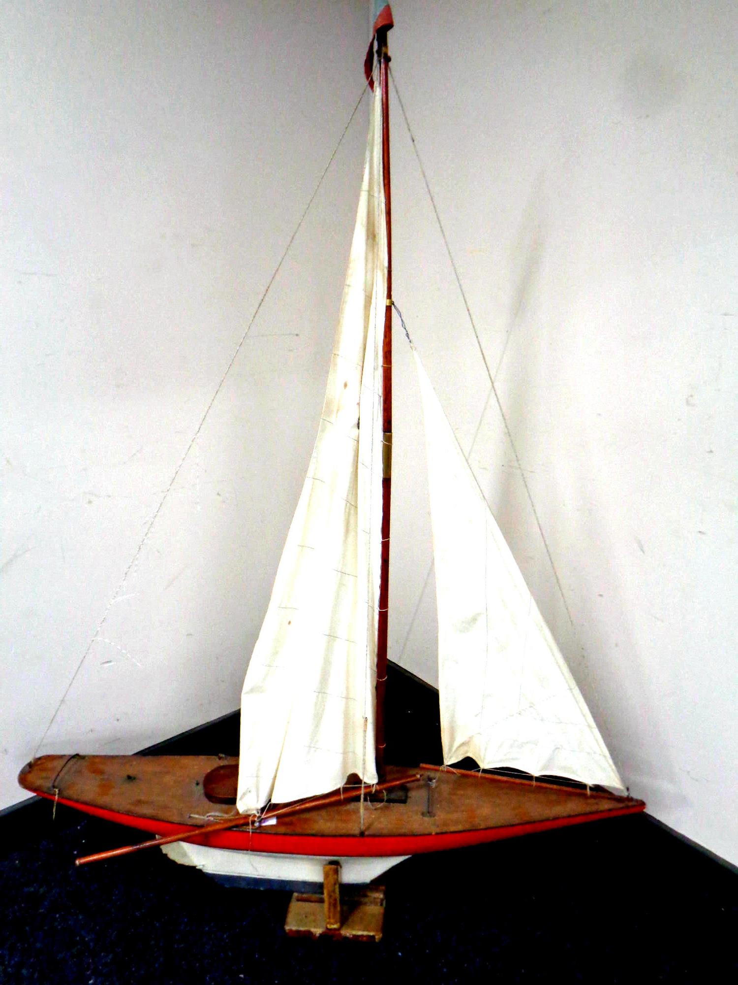 A large wooden model of a pond yacht on stand,