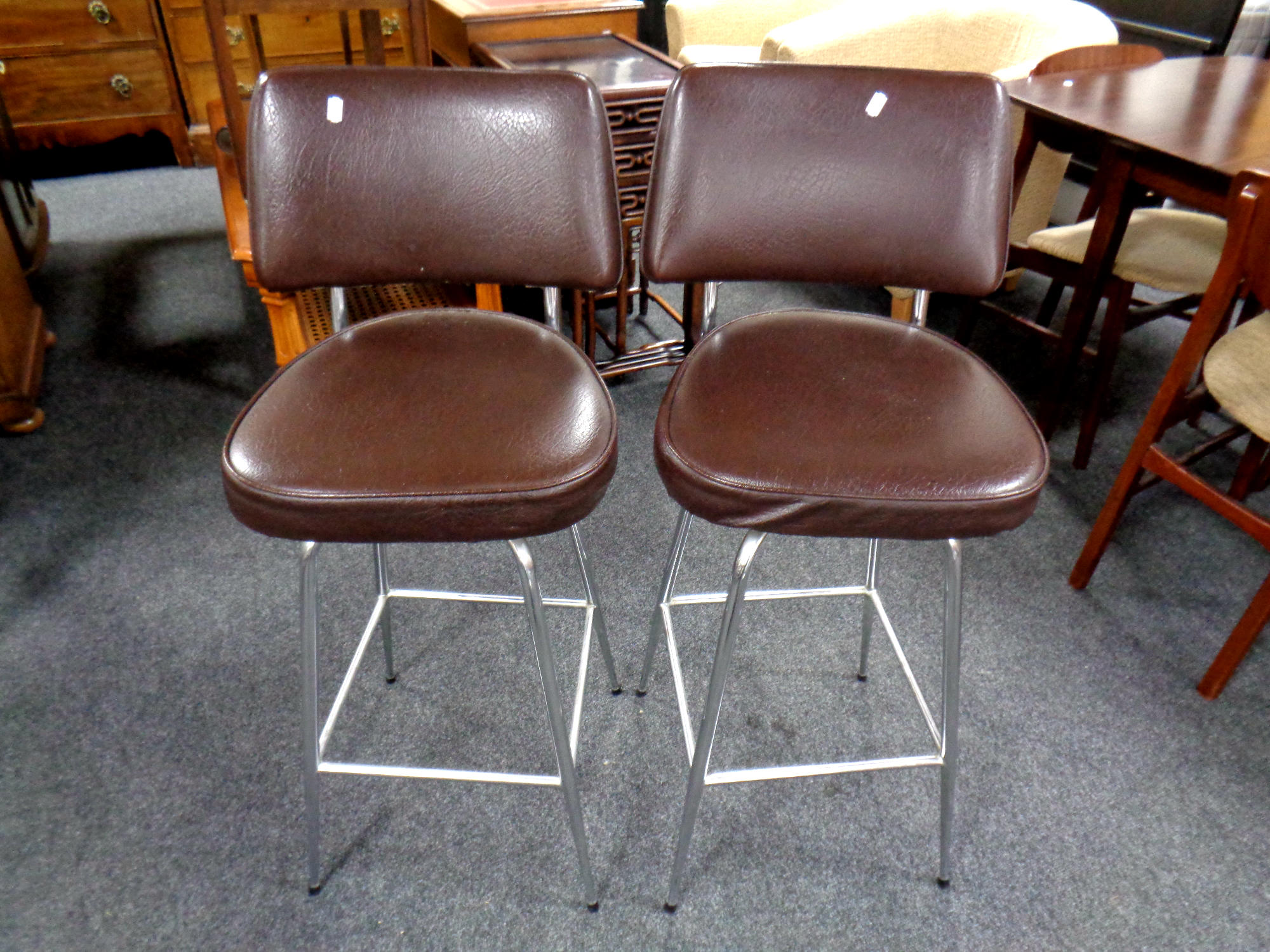 A pair of mid 20th century tubular metal and brown vinyl swivel bar chairs