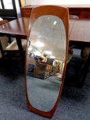 A mid 20th century mirror mounted on a teak board