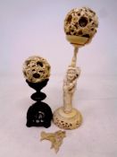 Two 19th century carved Chinese ivory puzzle balls, one on a carved hardwood stand, height 13 cm,
