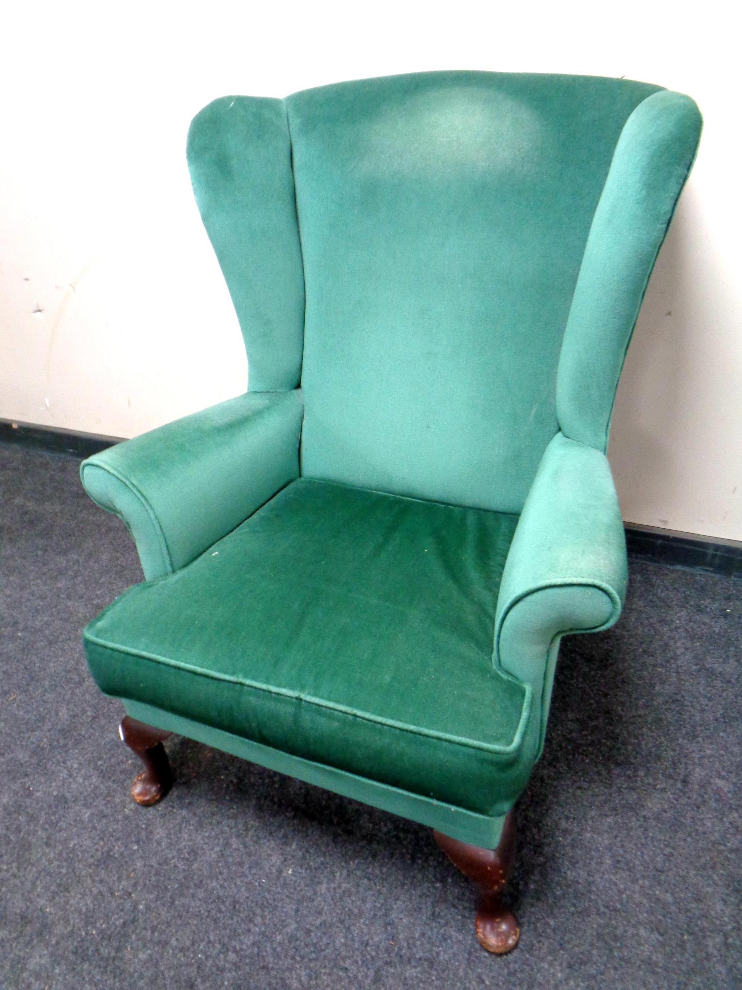 A 20th century green dralon upholstered wingback armchair