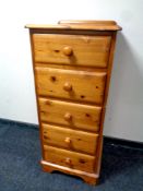 A narrow pine five drawer chest,