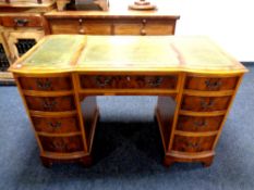 A Regency style nine drawer twin pedestal desk with three tooled leather inset panels,