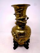 A Chinese embossed brass vase depicting dragons, height 25 cm, character marks to base,
