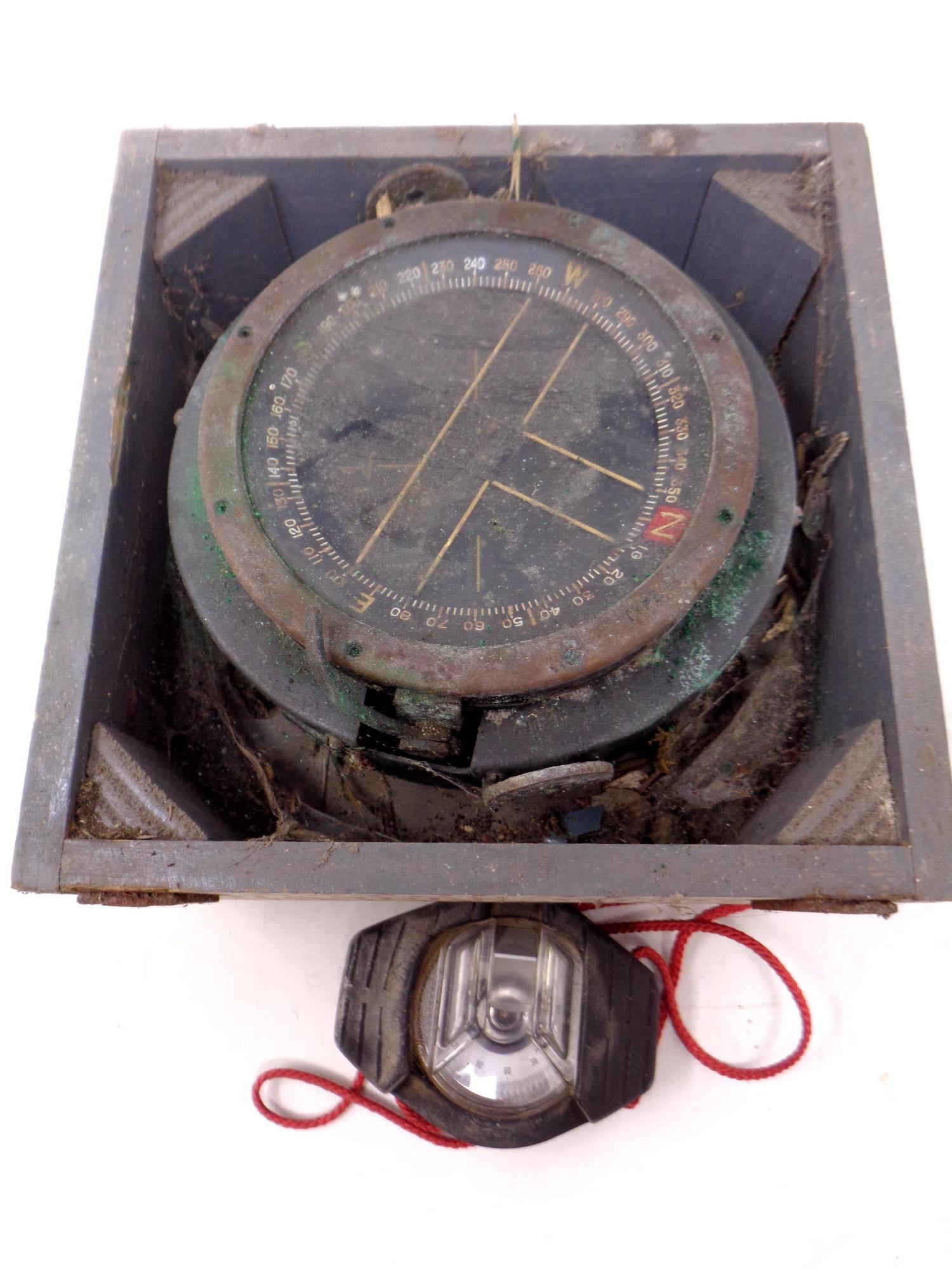 A military issue compass in a fitted box together with a further rubber cased pocket compass