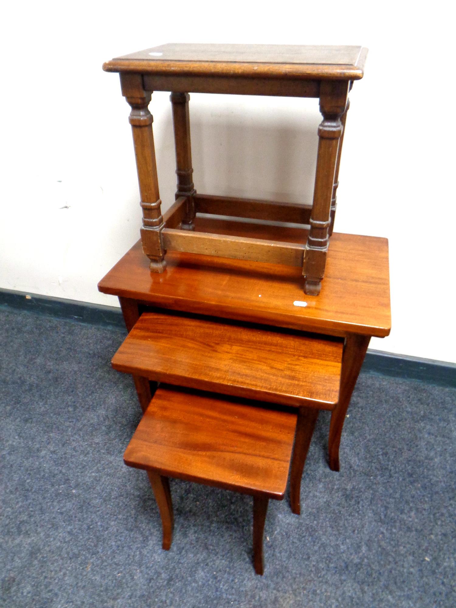 A nest of three mahogany tables together with an oak stool