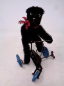 A mid 20th century mechanical wind up bear on tricycle