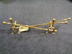 A pair of antique brass fire dogs with fire irons
