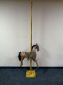 A wooden hand painted carousel horse on metal stand