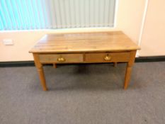 A light oak two drawer table,