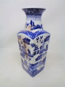 A blue and white willow pattern tall vase