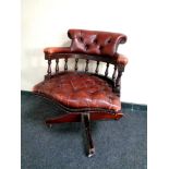 A buttoned burgundy leather swivel desk chair CONDITION REPORT: Currently unstable