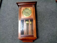 An Edwardian mahogany wall clock with pendulum and key